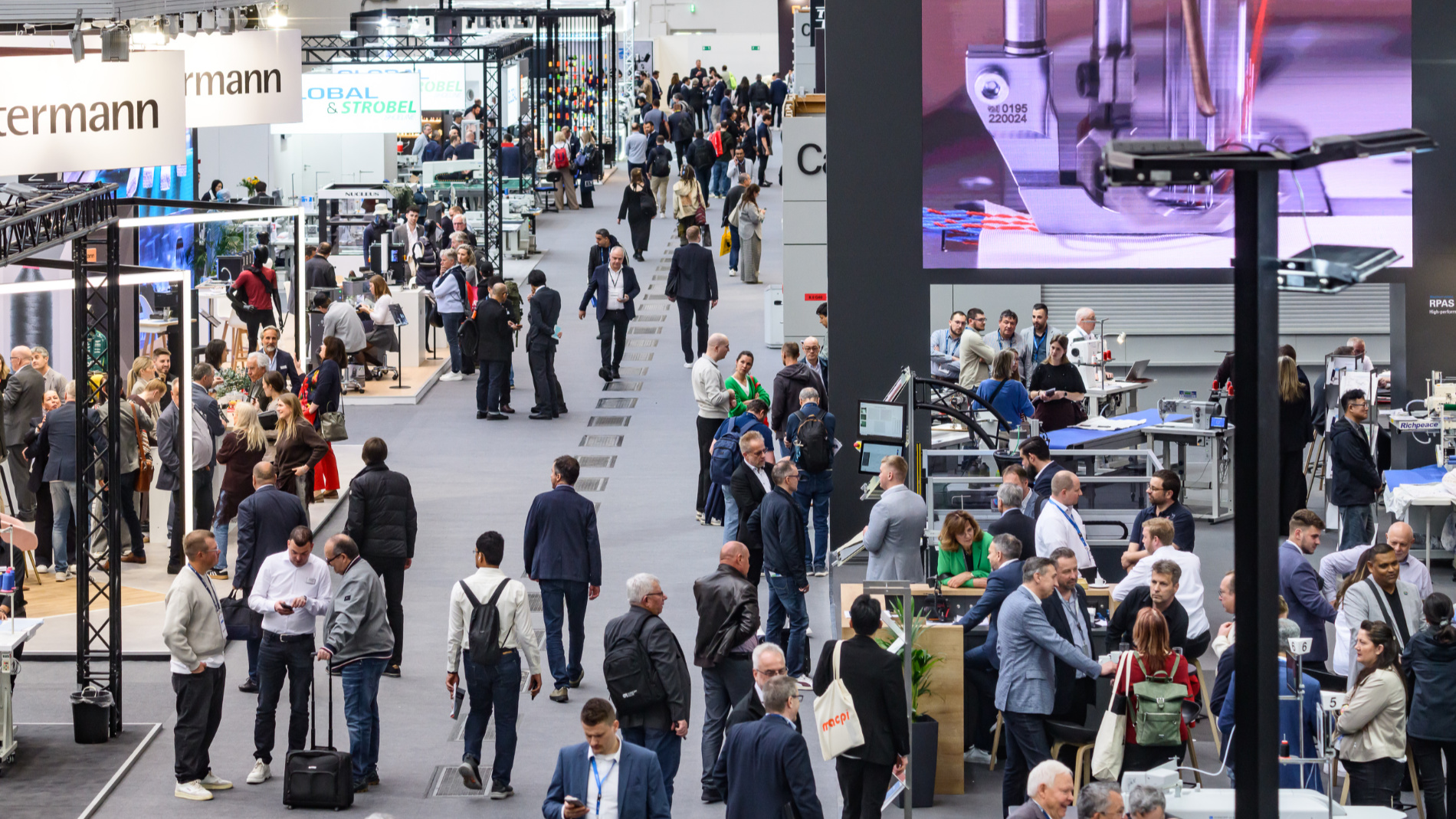 Blick über eine stark besuchte Messehalle der Texprocess